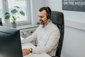 un homme portant un casque assis devant un ordinateur